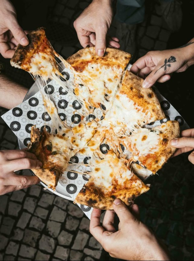 Amigos a partilhar pizza Generosa